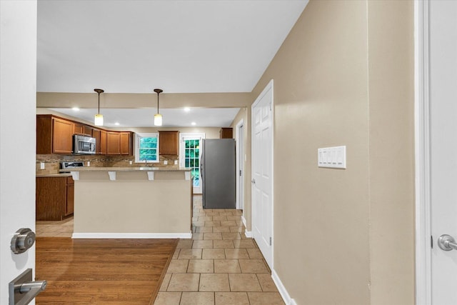 1204 Mayfair Rd, Champaign, IL 61821 - kitchen featuring stainless steel appliances, decorative backsplash, brown cabinetry, light countertops, and recessed lighting