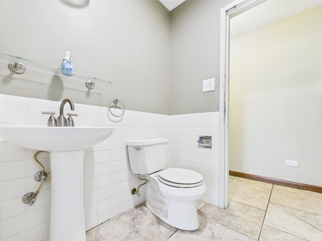 2208 Fiesta Dr, Joliet, IL 60432 - half bath featuring toilet, tile walls, tile patterned floors, wainscoting, and a sink