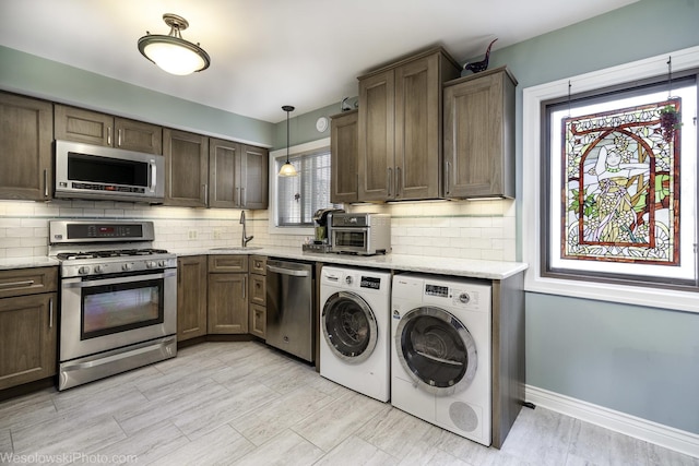 4876 N Hermitage Ave Unit 104, Chicago, IL 60640 - kitchen with appliances with stainless steel finishes, independent washer and dryer, a sink, and backsplash