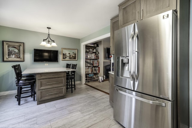 4876 N Hermitage Ave Unit 104, Chicago, IL 60640 - kitchen featuring stainless steel fridge, a breakfast bar, baseboards, and wood finish floors