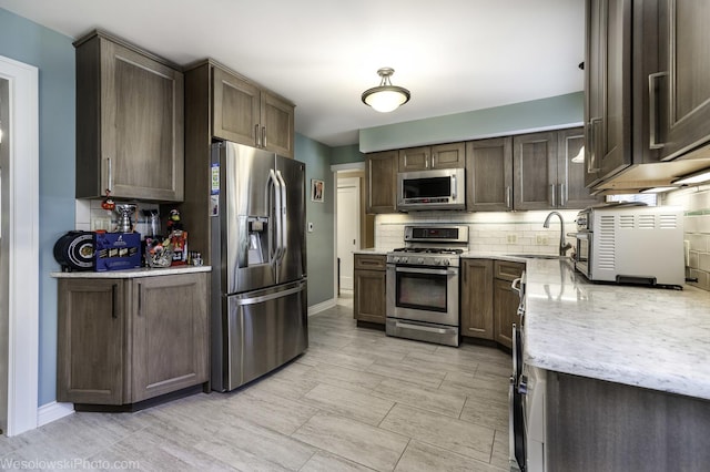 4876 N Hermitage Ave Unit 104, Chicago, IL 60640 - kitchen with appliances with stainless steel finishes, a sink, decorative backsplash, and baseboards