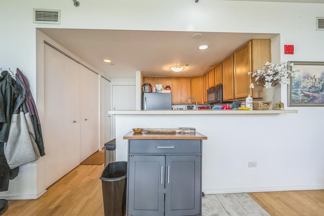 61 W 15th St Unit 407, Chicago, IL 60605 - kitchen featuring freestanding refrigerator, black microwave, a peninsula, light wood finished floors, and light countertops