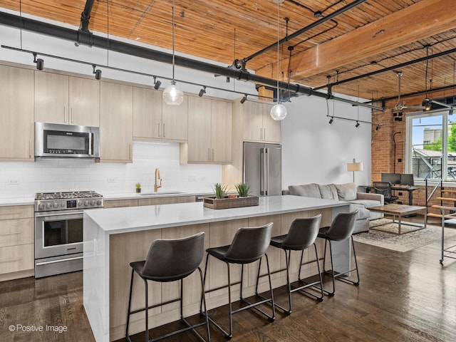 1725 W N Ave Unit 204, Chicago, IL 60622 - kitchen featuring stainless steel appliances, a sink, light countertops, a center island, and dark wood-type flooring