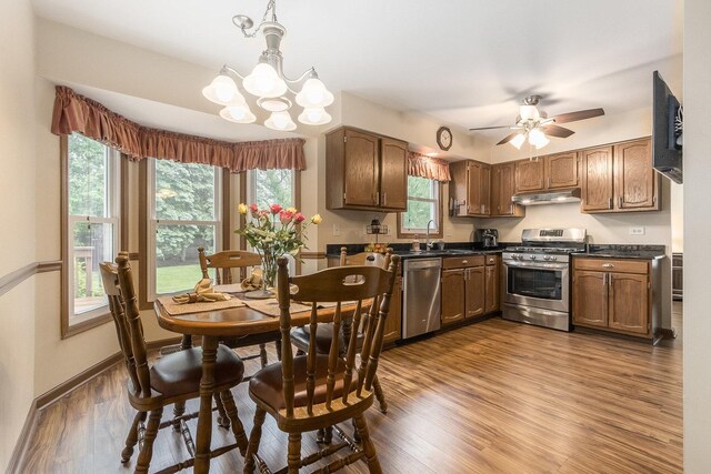 2975 Partridge Ct, Aurora, IL 60502 - kitchen with appliances with stainless steel finishes, under cabinet range hood, dark countertops, dark wood-type flooring, and a chandelier