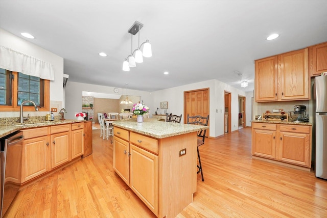 22314 Jeanette Ct, Frankfort, IL 60423 - kitchen with appliances with stainless steel finishes, a sink, light wood finished floors, a kitchen bar, and recessed lighting