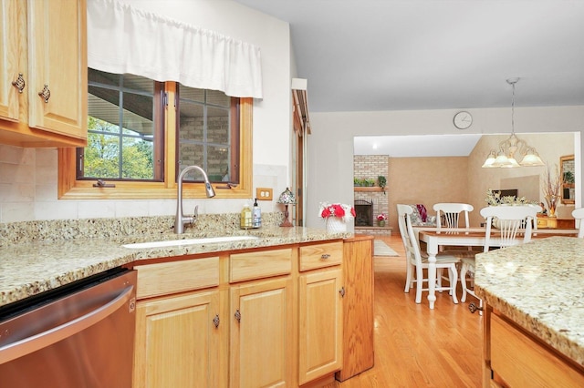22314 Jeanette Ct, Frankfort, IL 60423 - kitchen with dishwasher, a sink, light wood-style floors, a fireplace, and light stone counters