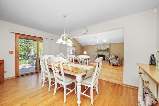 22314 Jeanette Ct, Frankfort, IL 60423 - dining space with light wood finished floors, a brick fireplace, a chandelier, vaulted ceiling, and baseboards