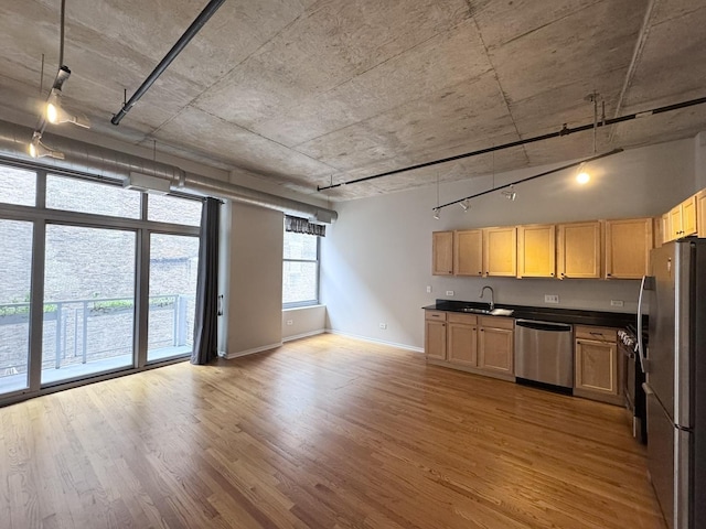 933 W Van Buren St Unit 424, Chicago, IL 60607 - kitchen featuring appliances with stainless steel finishes, open floor plan, light wood-style flooring, dark countertops, and track lighting