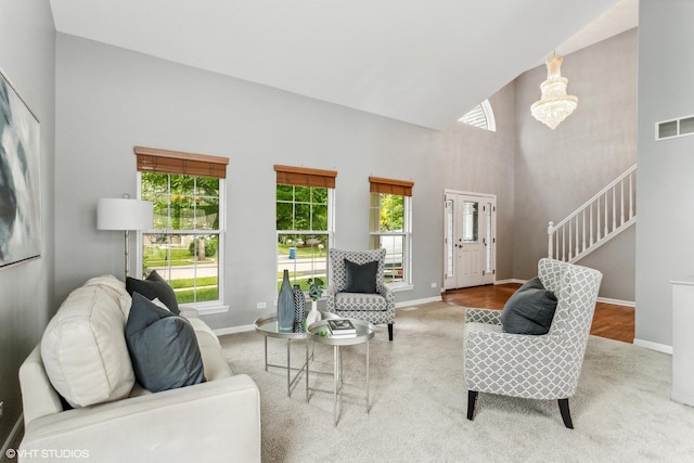 2136 Colonial St, Aurora, IL 60503 - carpeted living area with baseboards, high vaulted ceiling, stairway, and a chandelier
