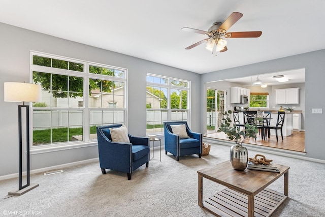 2136 Colonial St, Aurora, IL 60503 - living area featuring light colored carpet, baseboards, and ceiling fan