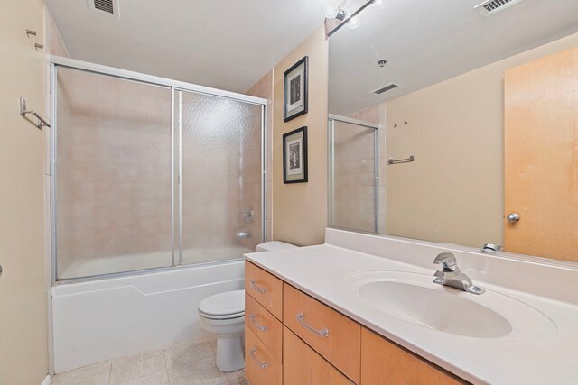 420 S Clinton St Unit 102A, Chicago, IL 60607 - bathroom featuring tile patterned floors, toilet, vanity, and combined bath / shower with glass door