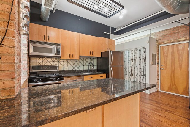 420 S Clinton St Unit 102A, Chicago, IL 60607 - kitchen featuring appliances with stainless steel finishes, a sink, light brown cabinets, backsplash, and light wood finished floors