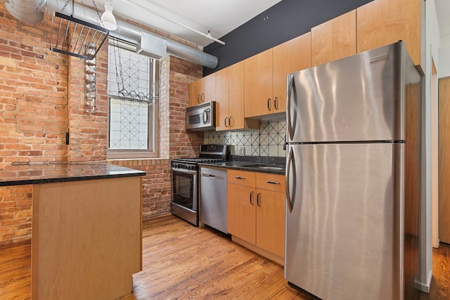 420 S Clinton St Unit 102A, Chicago, IL 60607 - kitchen featuring appliances with stainless steel finishes, light wood-style floors, brick wall, backsplash, and light brown cabinets