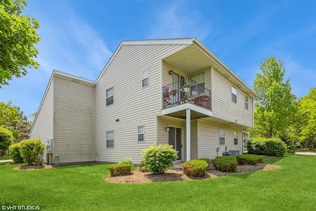 view of side of home featuring a balcony and a yard