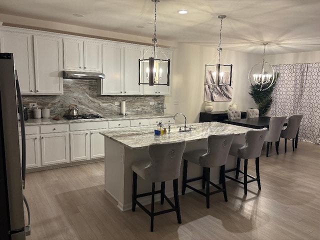 12305 S Prairie Ridge Ln, Plainfield, IL 60585 - kitchen with freestanding refrigerator, a chandelier, under cabinet range hood, backsplash, and recessed lighting