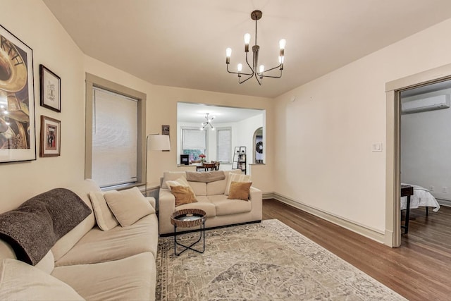 4433 N Artesian Ave, Chicago, IL 60625 - living area with a chandelier, wood finished floors, an AC wall unit, baseboards, and arched walkways