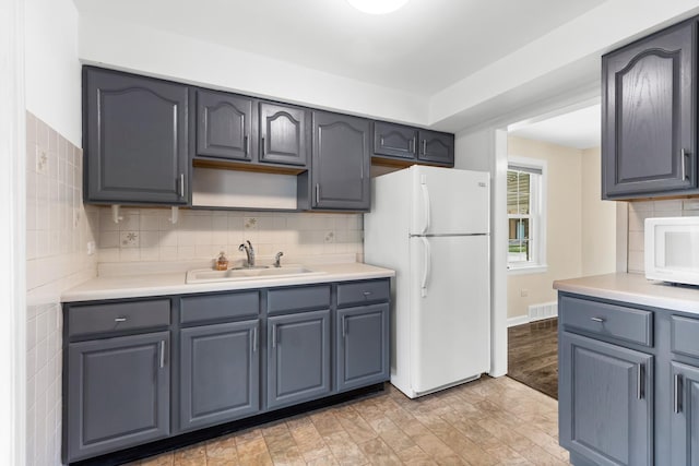 5471 N Octavia Ave, Chicago, IL 60656 - kitchen featuring white appliances, a sink, tasteful backsplash, light countertops, and light wood-style floors