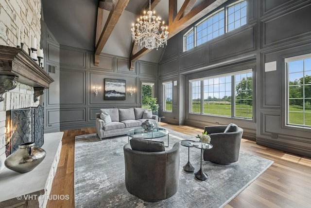 14 Vandenbergh Dr, South Barrington, IL 60010 - living room featuring a decorative wall, high vaulted ceiling, a chandelier, wood finished floors, and a stone fireplace