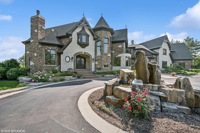 14 Vandenbergh Dr, South Barrington, IL 60010 - view of front of home with a chimney, stone siding, curved driveway, and brick siding