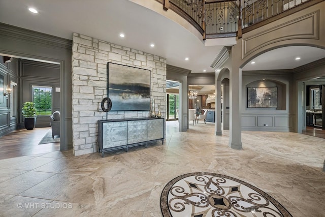 14 Vandenbergh Dr, South Barrington, IL 60010 - living room featuring crown molding, decorative columns, a decorative wall, a high ceiling, and arched walkways