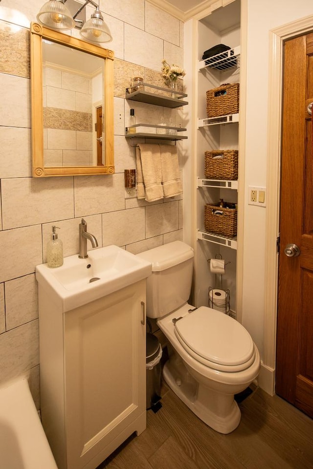 307 Highland Rd, Grayslake, IL 60030 - bathroom featuring vanity, backsplash, tile walls, wood finished floors, and ornamental molding
