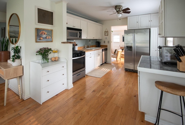 307 Highland Rd, Grayslake, IL 60030 - kitchen with appliances with stainless steel finishes, a ceiling fan, light wood-type flooring, and white cabinetry