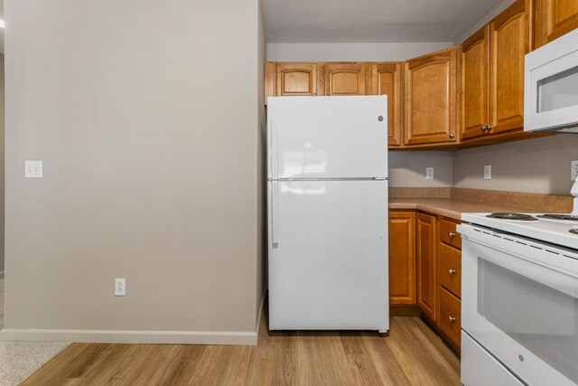 3418 Stoneway Ct, Champaign, IL 61822 - kitchen with white appliances, light wood-type flooring, light countertops, brown cabinetry, and baseboards