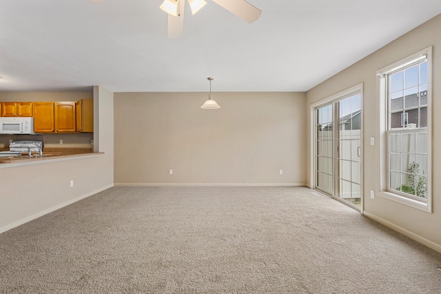 3418 Stoneway Ct, Champaign, IL 61822 - unfurnished living room featuring a sink, light carpet, baseboards, and a ceiling fan