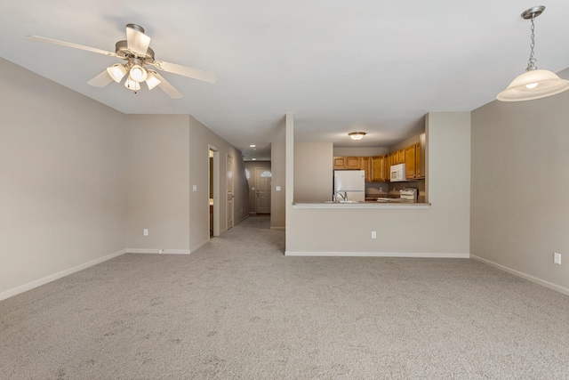 3418 Stoneway Ct, Champaign, IL 61822 - unfurnished living room with baseboards, light carpet, ceiling fan, and a sink