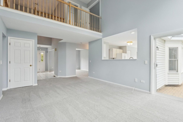 1173 Lamb Ln, Gurnee, IL 60031 - unfurnished living room with carpet floors, a high ceiling, and baseboards