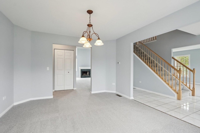 1173 Lamb Ln, Gurnee, IL 60031 - spare room with stairs, carpet floors, baseboards, a fireplace, and a chandelier