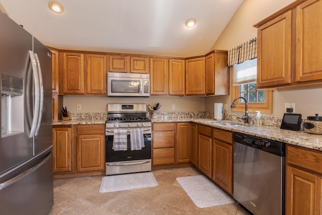 5 Tatiana Ct, Bloomington, IL 61704 - kitchen featuring appliances with stainless steel finishes, brown cabinetry, vaulted ceiling, light stone counters, and recessed lighting