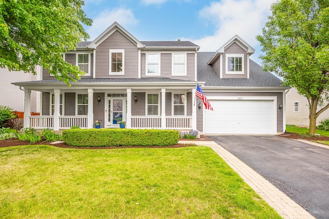 13825 Trillium Ln, Plainfield, IL 60544 - view of front of home with asphalt driveway, covered porch, a garage, and a front yard