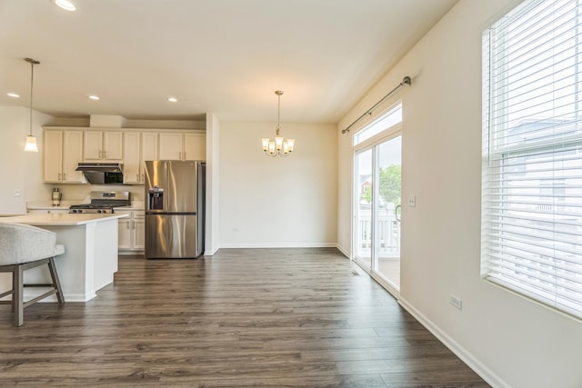 4138 Irving Rd, Aurora, IL 60504 - kitchen with appliances with stainless steel finishes, under cabinet range hood, a chandelier, dark wood-style floors, and decorative light fixtures