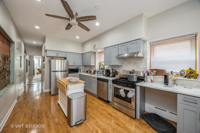 945 Elgin Ave, Forest Park, IL 60130 - kitchen with stainless steel appliances, gray cabinetry, under cabinet range hood, baseboard heating, and a ceiling fan