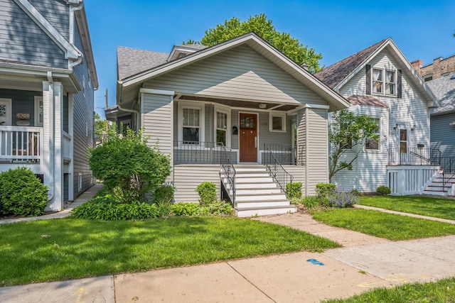 4248 N Sawyer Ave, Chicago, IL 60618 - bungalow-style house featuring stairs, covered porch, and a front lawn