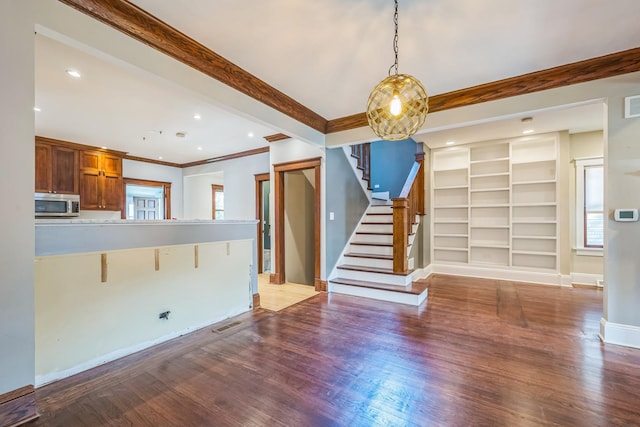4248 N Sawyer Ave, Chicago, IL 60618 - unfurnished living room with stairs, plenty of natural light, wood finished floors, crown molding, and baseboards