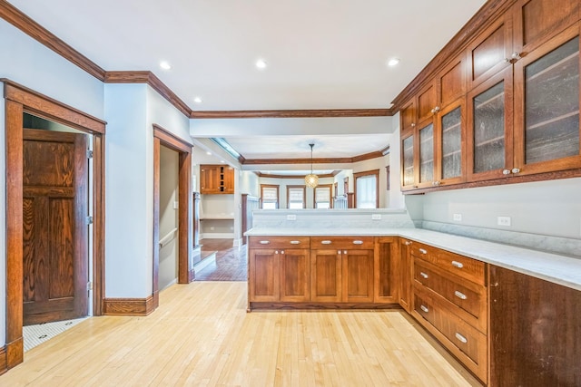 4248 N Sawyer Ave, Chicago, IL 60618 - kitchen with crown molding, a peninsula, light wood finished floors, glass insert cabinets, and brown cabinets