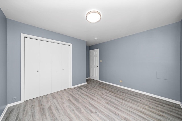 176 Monee Rd, Park Forest, IL 60466 - unfurnished bedroom with wood finished floors, baseboards, and a closet