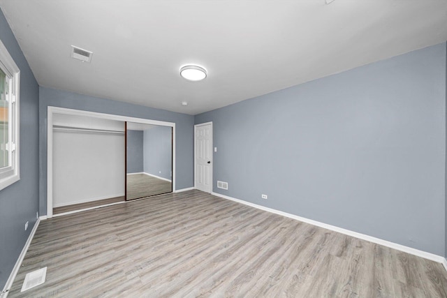 176 Monee Rd, Park Forest, IL 60466 - unfurnished bedroom with light wood finished floors, baseboards, and a closet