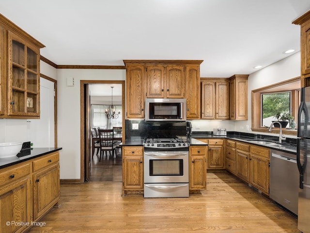 739 N E Ave, Oak Park, IL 60302 - kitchen featuring stainless steel appliances, a sink, dark countertops, brown cabinetry, and recessed lighting