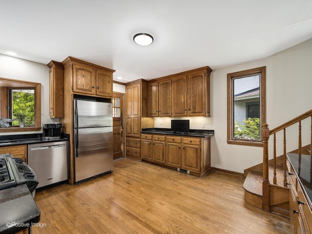 739 N E Ave, Oak Park, IL 60302 - kitchen with appliances with stainless steel finishes, light wood finished floors, brown cabinets, dark countertops, and recessed lighting