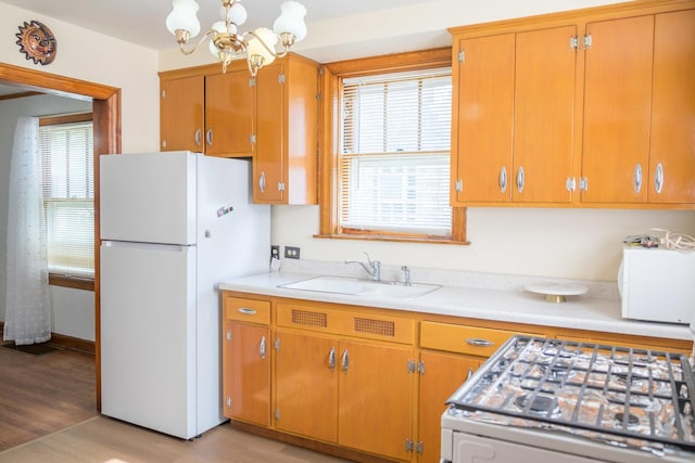 4948 S Lamon Ave, Chicago, IL 60638 - kitchen featuring freestanding refrigerator, a sink, stove, a chandelier, and light countertops
