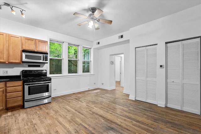 6812 N Wayne Ave Unit 1G, Chicago, IL 60626 - kitchen featuring stainless steel appliances, light wood-style flooring, dark countertops, and ceiling fan