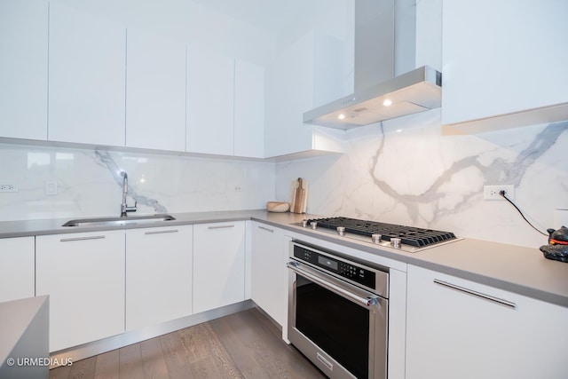367 W Locust St Unit 202, Chicago, IL 60610 - kitchen featuring stainless steel appliances, wall chimney range hood, a sink, and modern cabinets