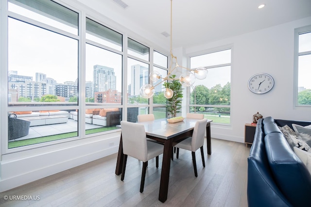 367 W Locust St Unit 202, Chicago, IL 60610 - dining room with wood finished floors, a city view, a chandelier, recessed lighting, and baseboards