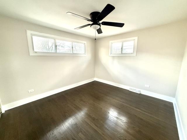 14409 Kimbark Ave, Dolton, IL 60419 - empty room with baseboards, dark wood-style floors, and a ceiling fan