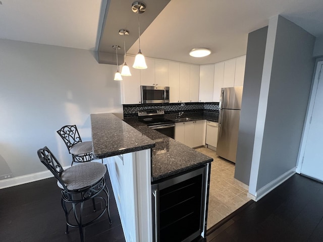 1850 N Clark St Unit 2106, Chicago, IL 60614 - kitchen featuring appliances with stainless steel finishes, wine cooler, a peninsula, a sink, and white cabinetry