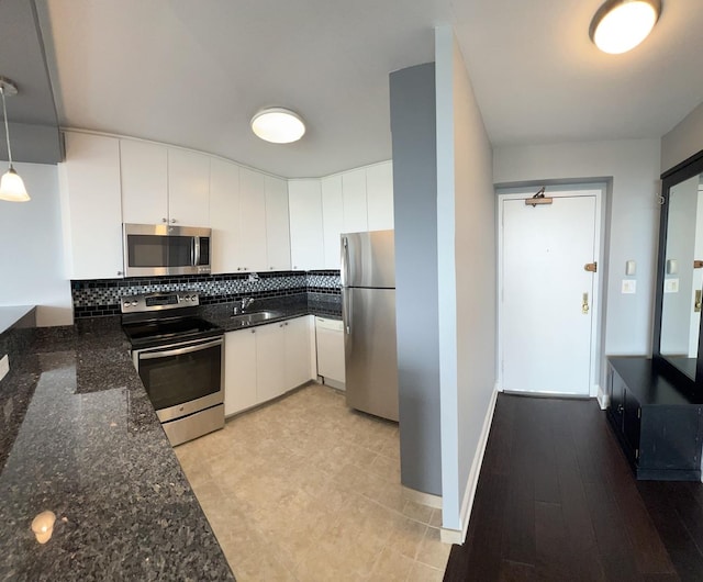 1850 N Clark St Unit 2106, Chicago, IL 60614 - kitchen featuring stainless steel appliances, a sink, dark stone countertops, backsplash, and white cabinetry