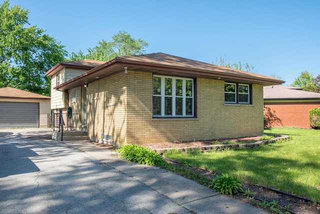 34 E 159th St, South Holland, IL 60473 - view of side of property with an outbuilding, brick siding, a garage, and a yard